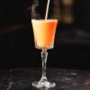 Flot timeless glas med orange drink i.